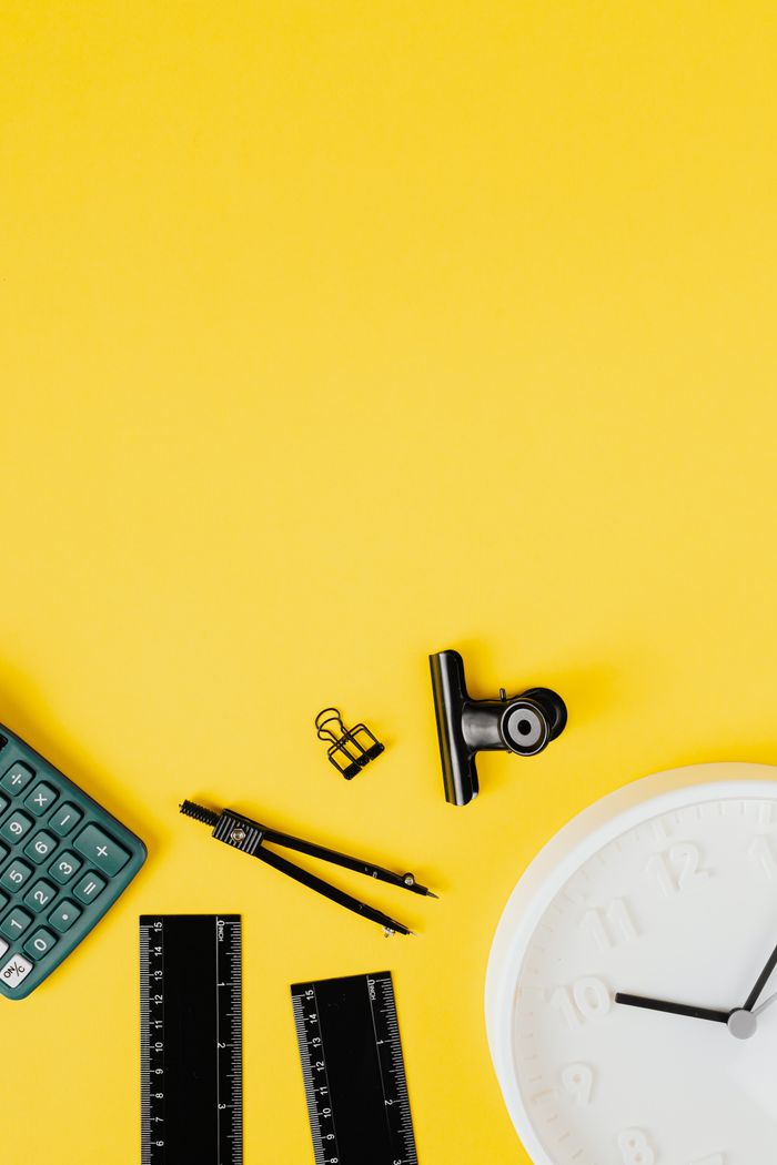 Services Flat lay of office supplies on a bright yellow background with ample copy space.