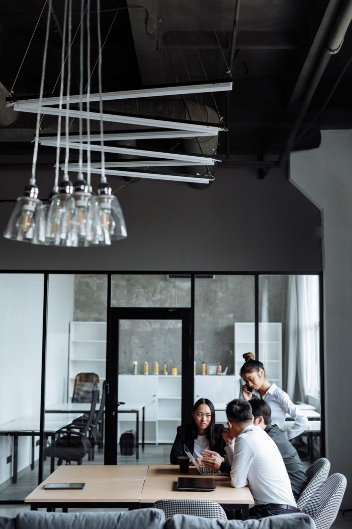 Services Business professionals engaged in a collaborative meeting in a stylish, modern office setting.