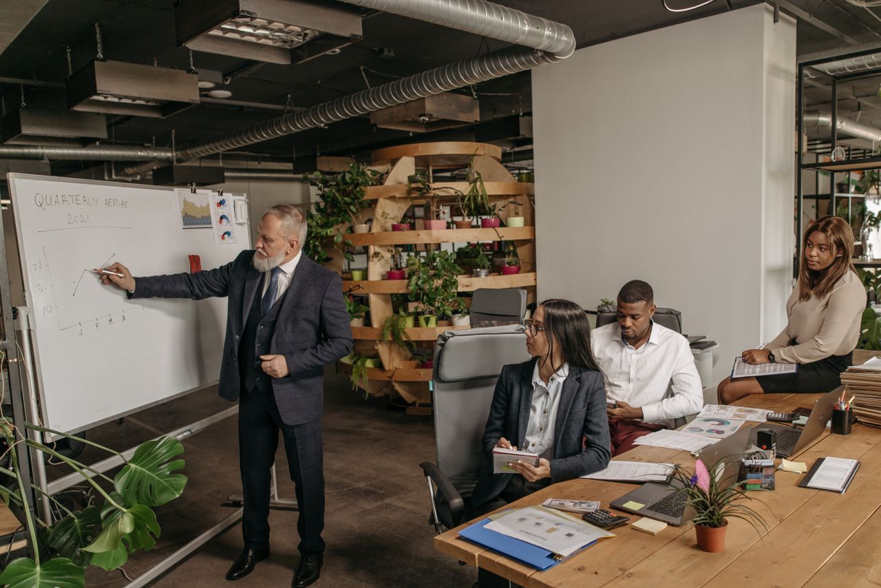 Crafting Captivating Headlines: Your awesome post title goes here Team in a modern office discussing quarterly earnings with a presentation.