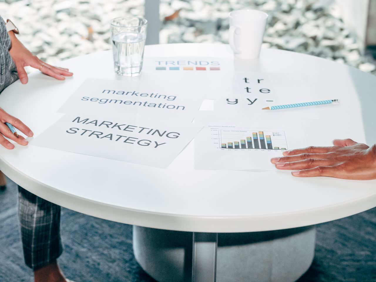 Services Two professionals collaborate on marketing strategy and segmentation at a round table.